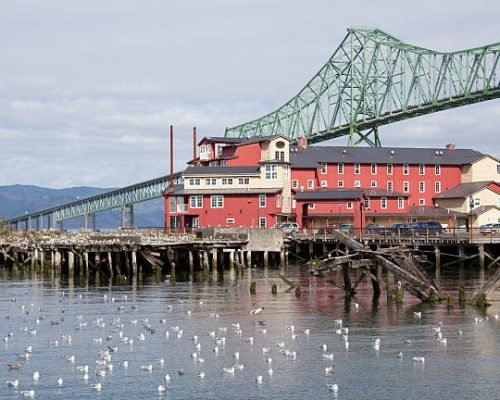 The wooden house standing next to the long bridge over Columbia River (Astoria, Oregon).